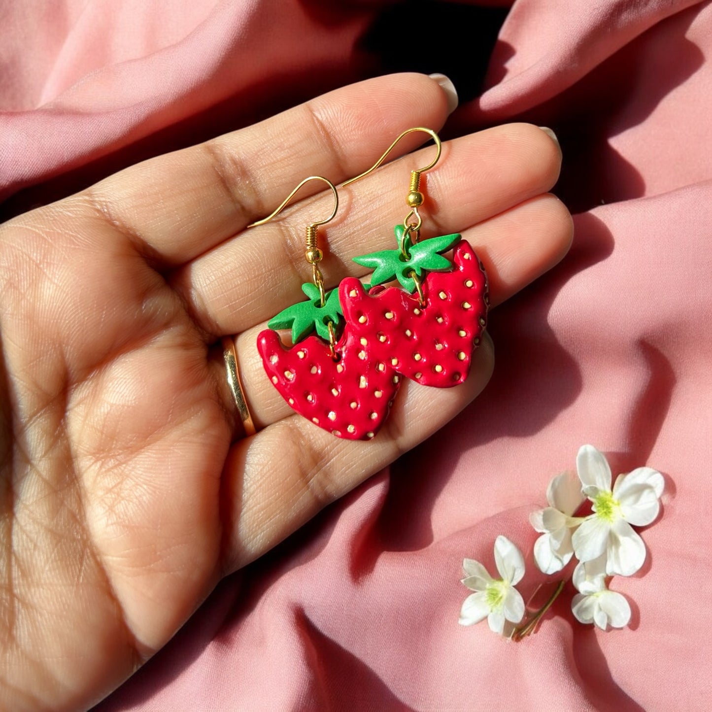 Lightweight red and green dangle earrings on display