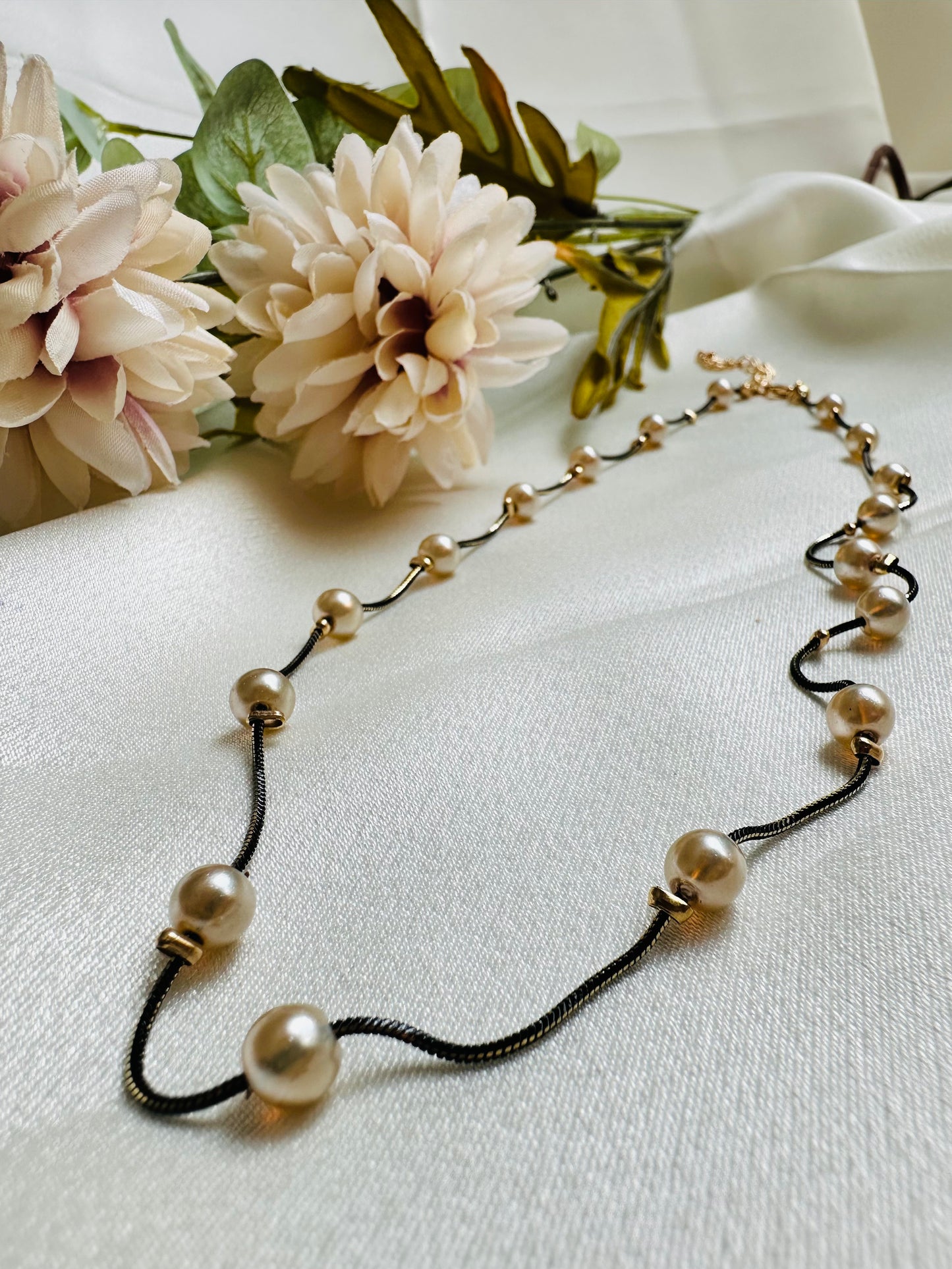 Black and gold coloured multi shaded chain Necklace with Beige coloured Pearl (Faux)  placed at equidistance. Elegant Statement Jewellery with adjustable hook and chain.