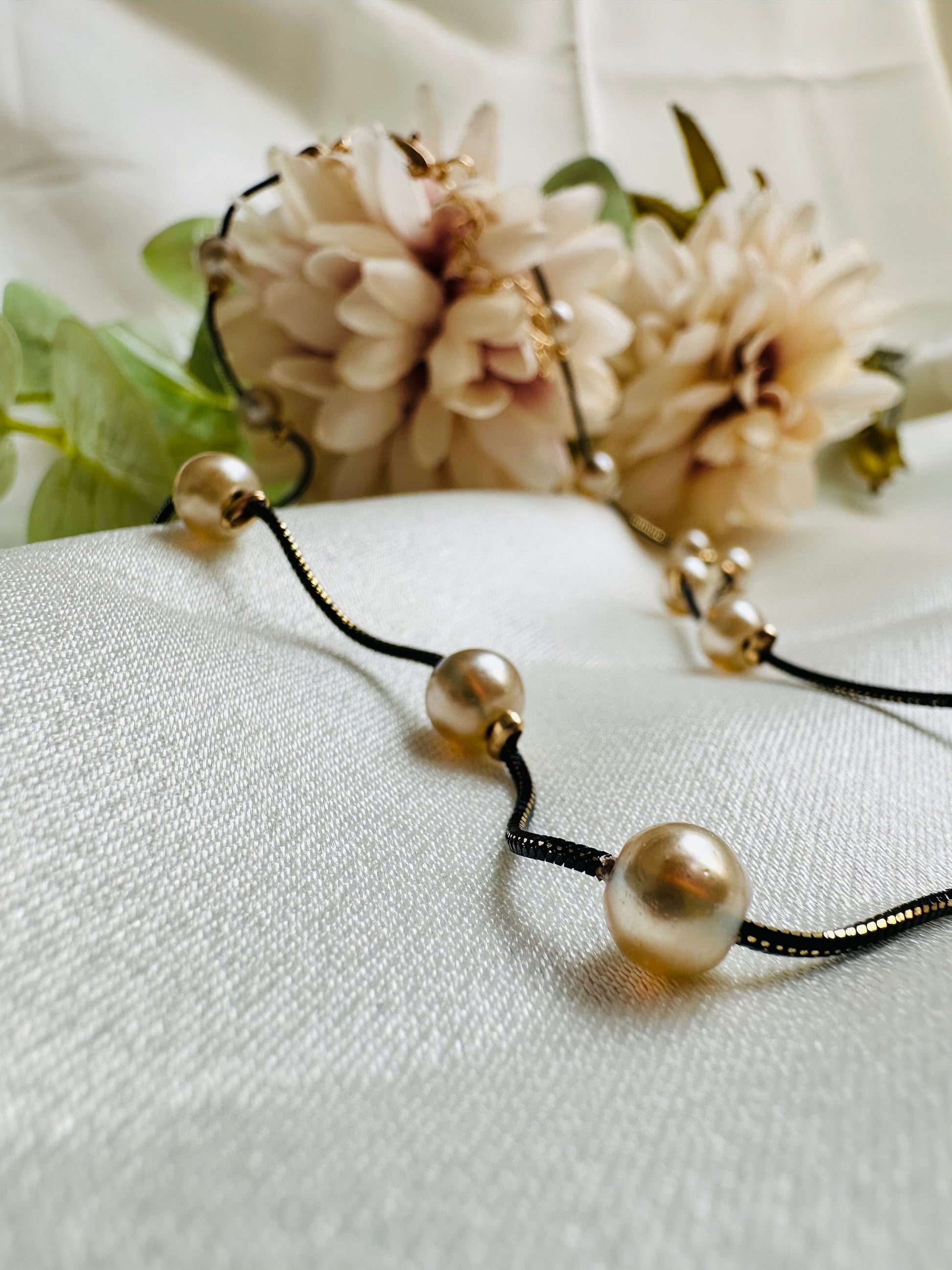 Black and gold coloured multi shaded chain Necklace with Beige coloured Pearl (Faux)  placed at equidistance. Elegant Statement Jewellery with adjustable hook and chain.