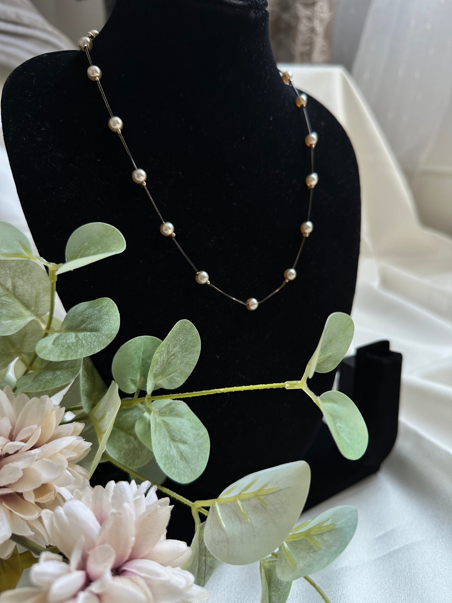 Black and gold coloured multi shaded chain Necklace with Beige coloured Pearl (Faux)  placed at equidistance. Elegant Statement Jewellery with adjustable hook and chain.