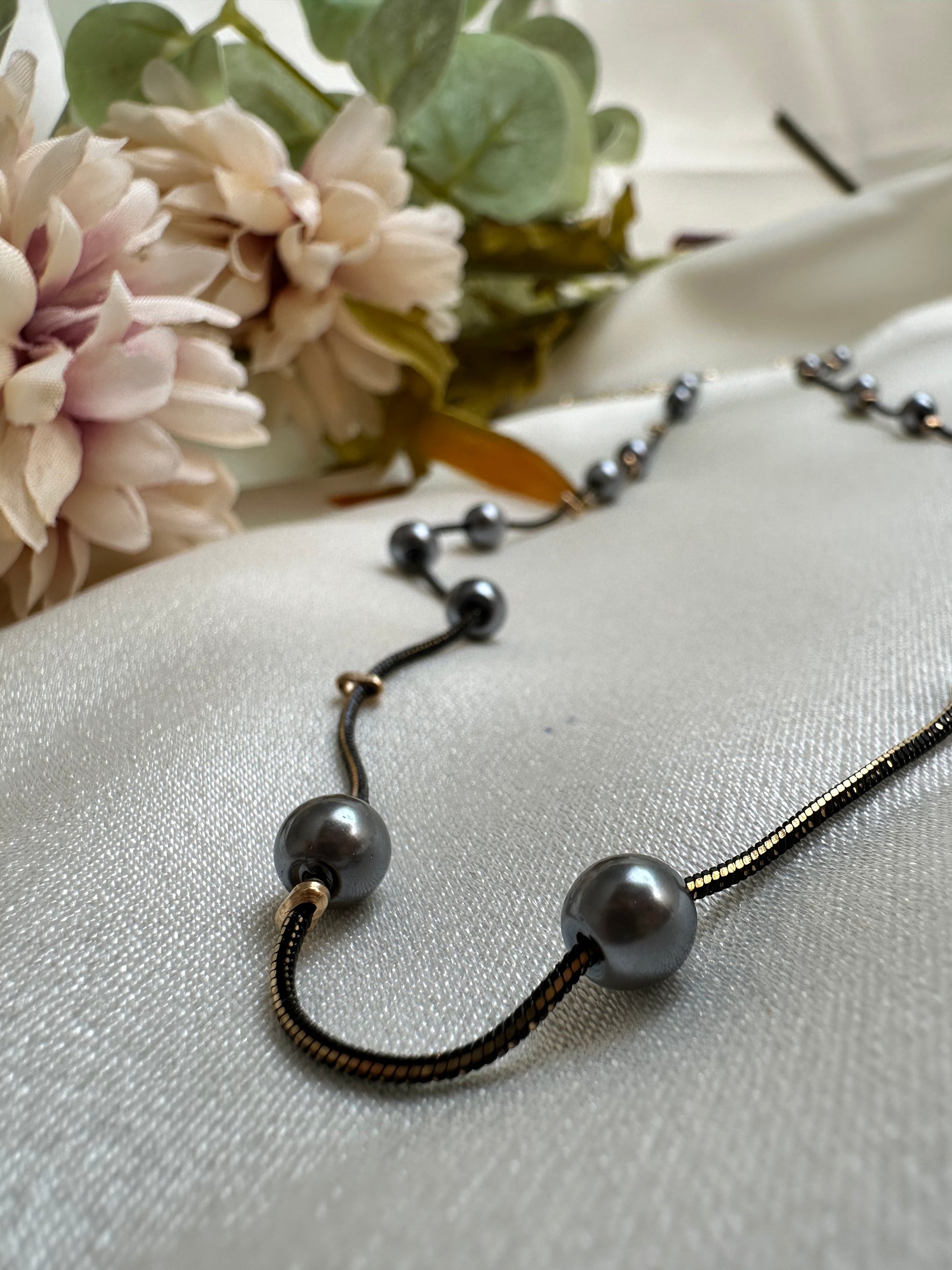 Black and gold coloured multi shaded chain Necklace with Grey coloured Pearl (Faux)  placed at equidistance. Elegant Statement Jewellery with adjustable hook and chain.