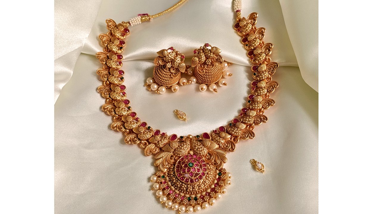 Peacock inspired temple jewellery necklace and jhumkas on a black neck stand