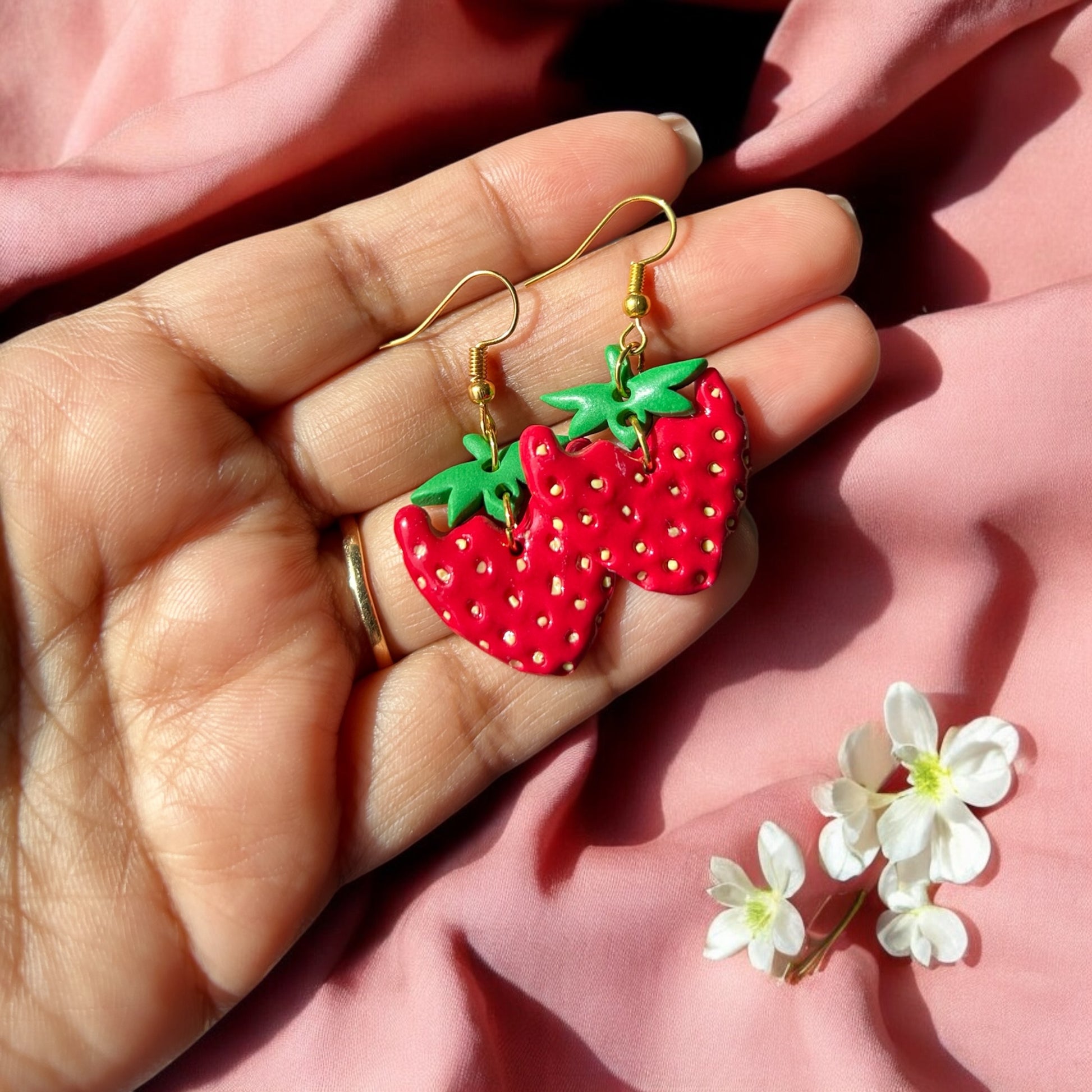 Lightweight red and green dangle earrings on display