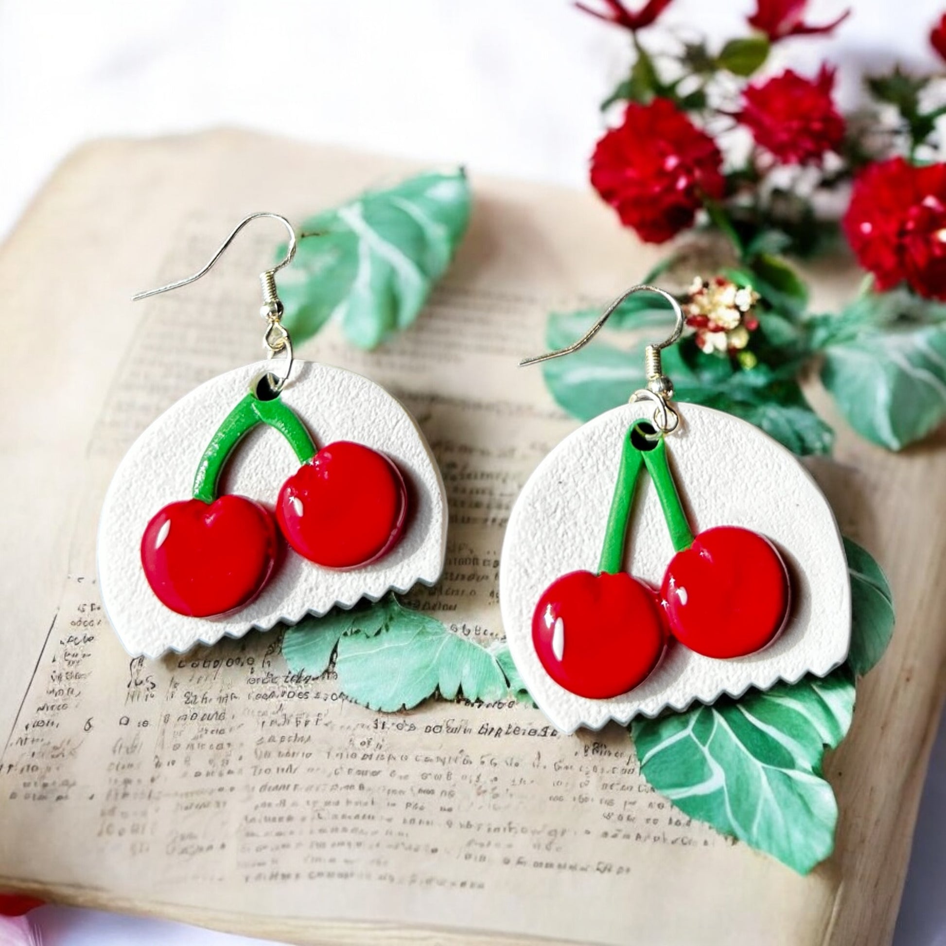 Close-up of handmade cherry on ivory flat base dangle earrings
