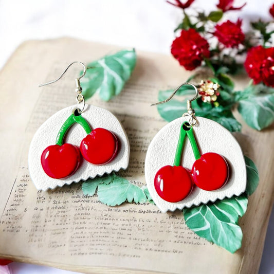 Close-up of handmade cherry on ivory flat base dangle earrings