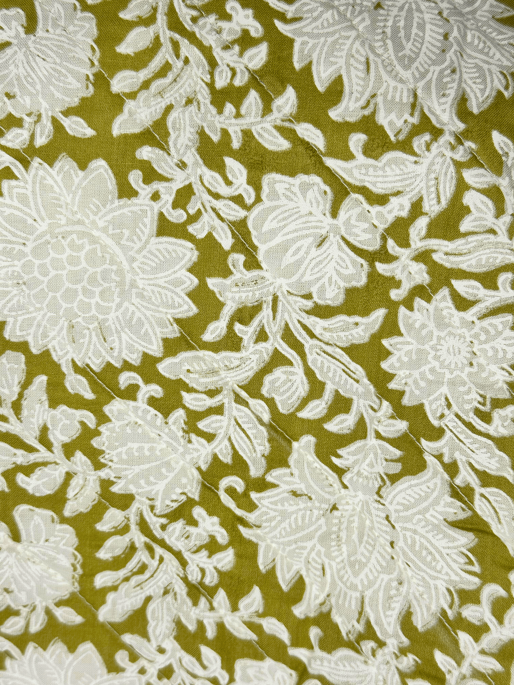 White floral pattern on a green background quilted cushion cover