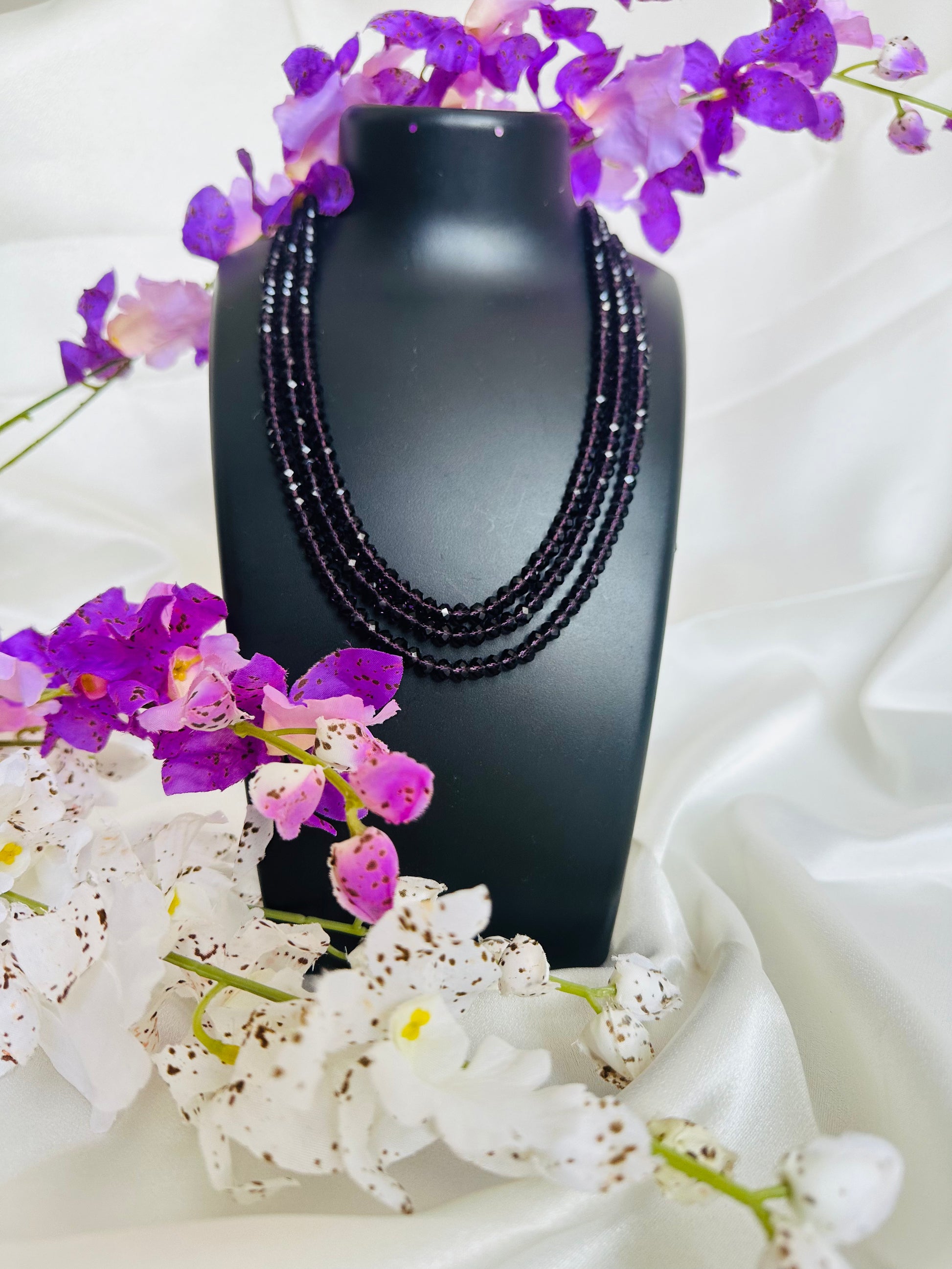 Aubergine coloured 3 Layered Crystal Beaded handmade Necklace on a display neck