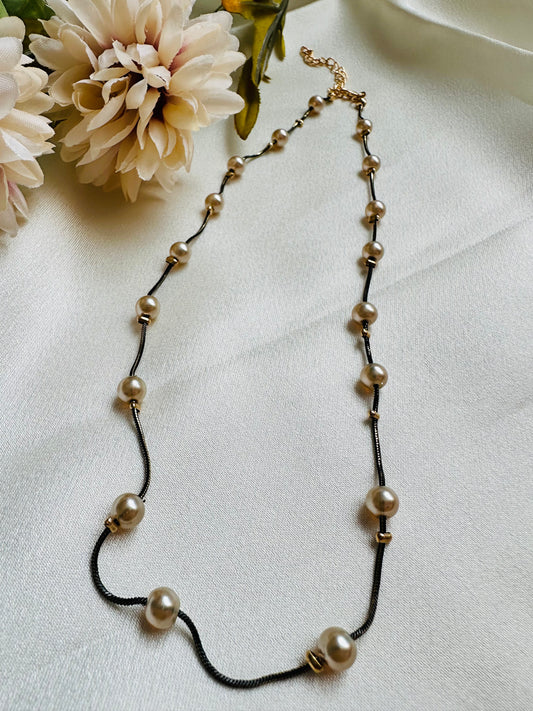 Black coloured chain Necklace with Beige coloured Pearl (Faux)  placed at equidistance. Elegant Statement Jewellery with adjustable hook and chain. 