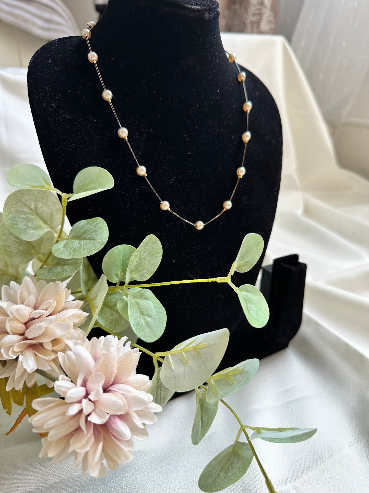 Black coloured chain Necklace with Beige coloured Pearl (Faux)  placed at equidistance. Elegant Statement Jewellery with adjustable hook and chain. 