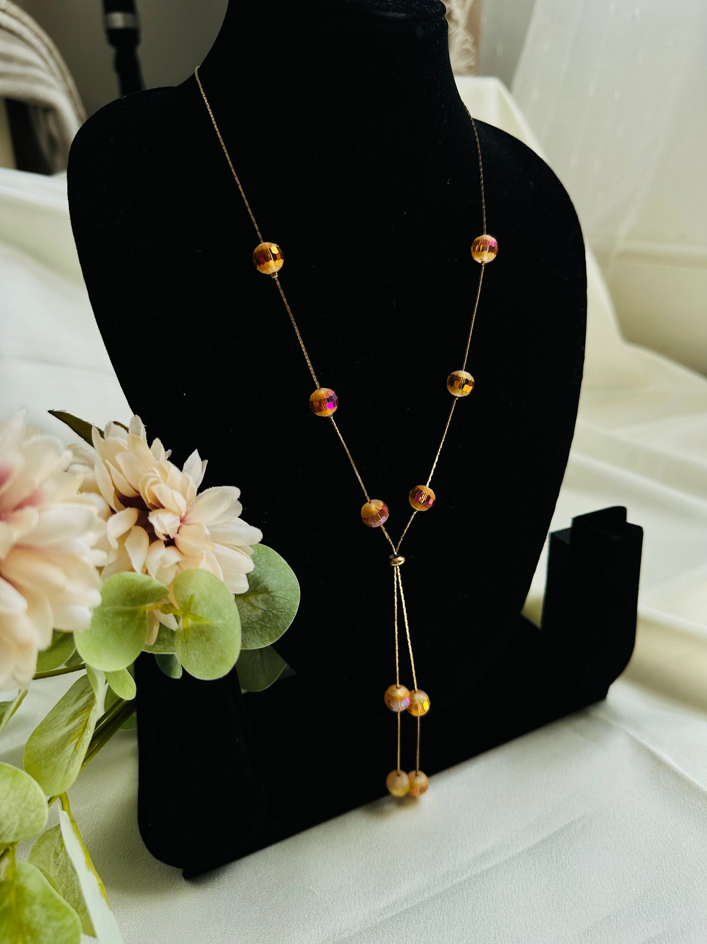 Beads on Chain adjustable unique  fashion necklace with amber coloured crystal beads on a display neck