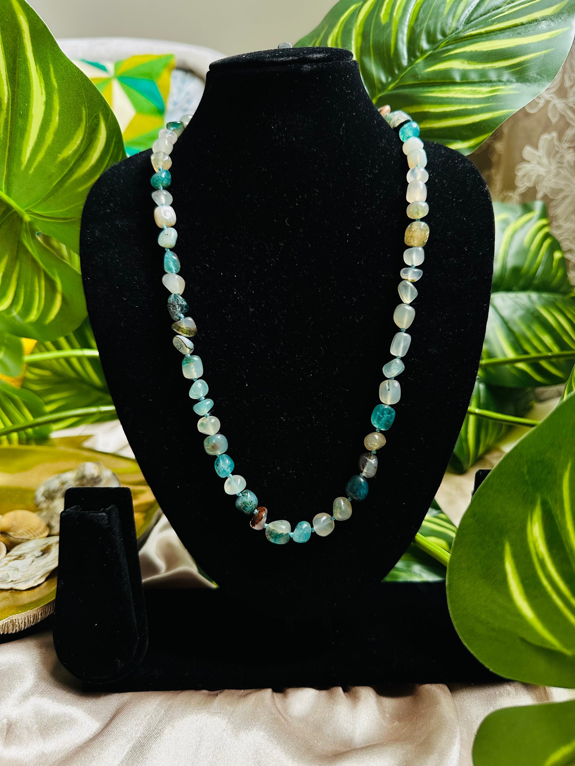 Aqua coloured Stone Beaded Necklace, Handcrafted Elegance, statement piece on a display neck