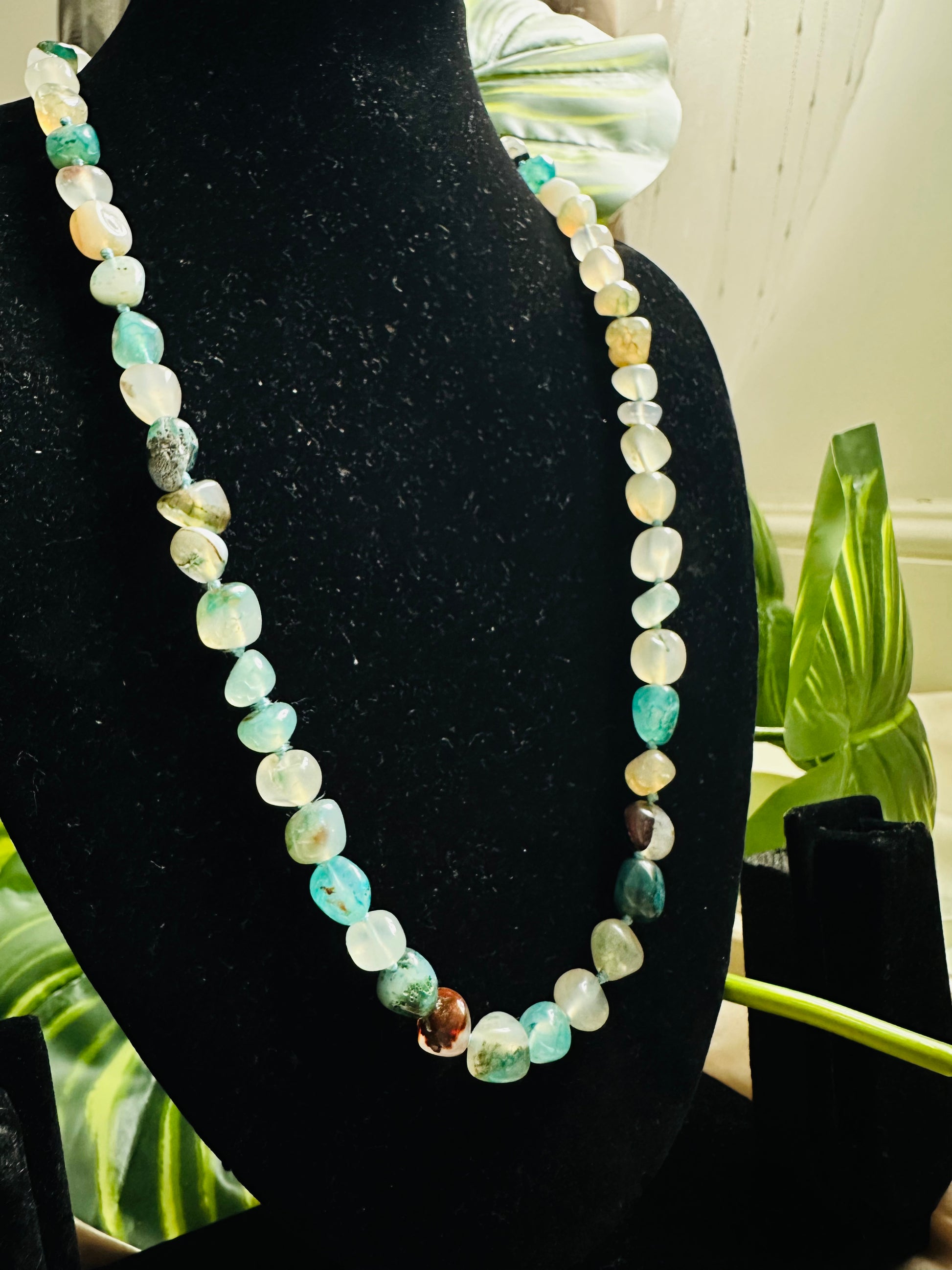 Aqua coloured Stone Beaded Necklace, Handcrafted Elegance, statement piece on a display neck