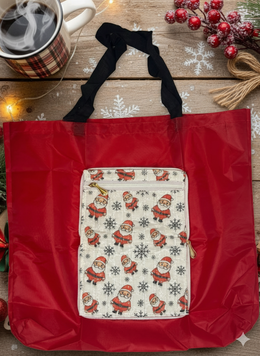 Red shopper bag with Santa Claus patterned pocket in front on a wooden surface with a mug and decorative items.
